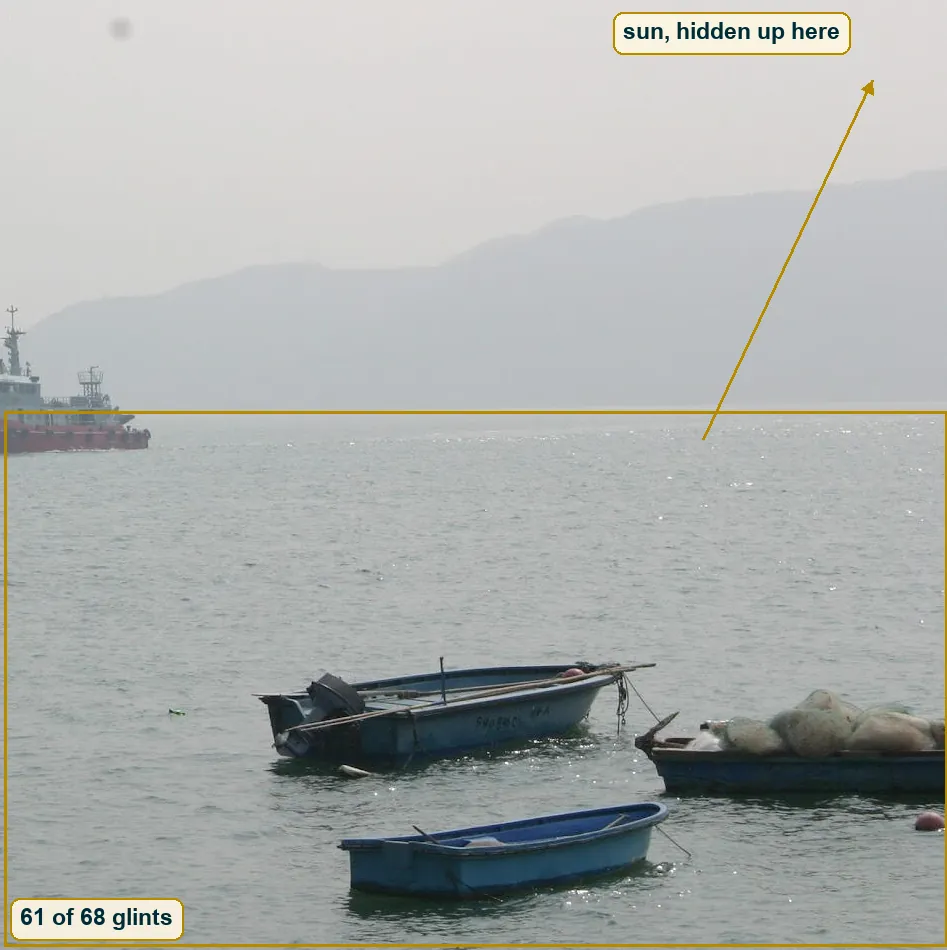 Right half of the photo with an arrow from the band of sun glints on the water up to the hazy sky