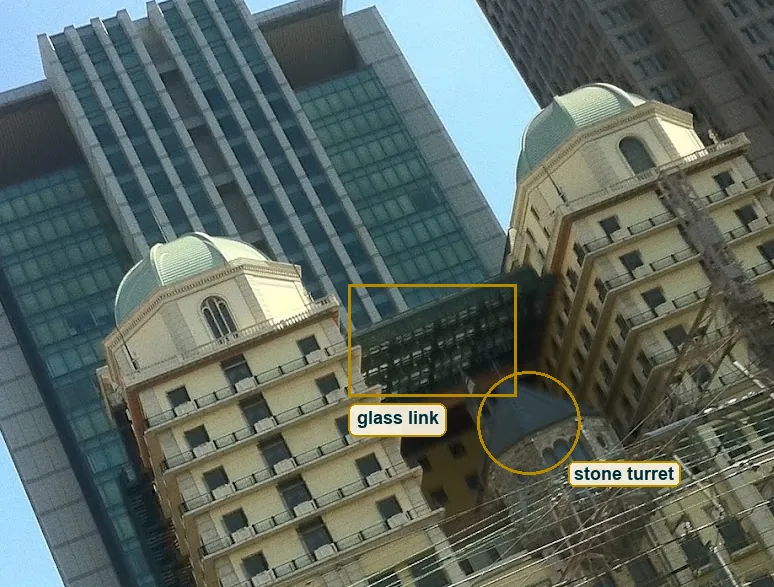 Crop of the cream towers with the stone turret and the glass link marked