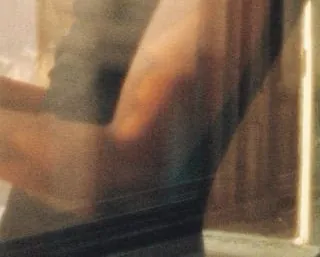 Pixels at full size from her bent arm and dark T-shirt, showing the grain
